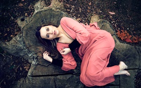 Розовое платье девушка лежала на пне
